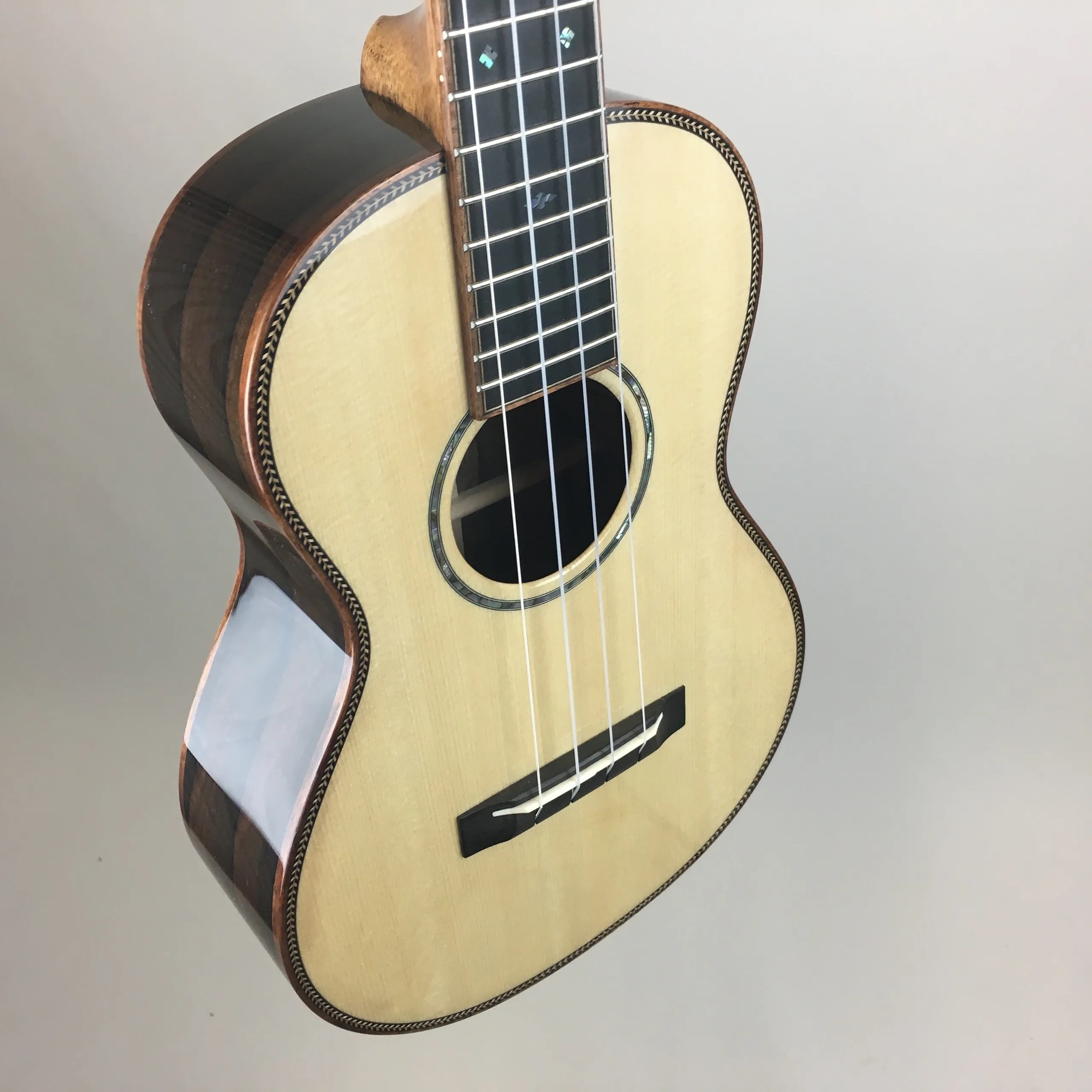 Micah in the spray booth with a finished ukulele
