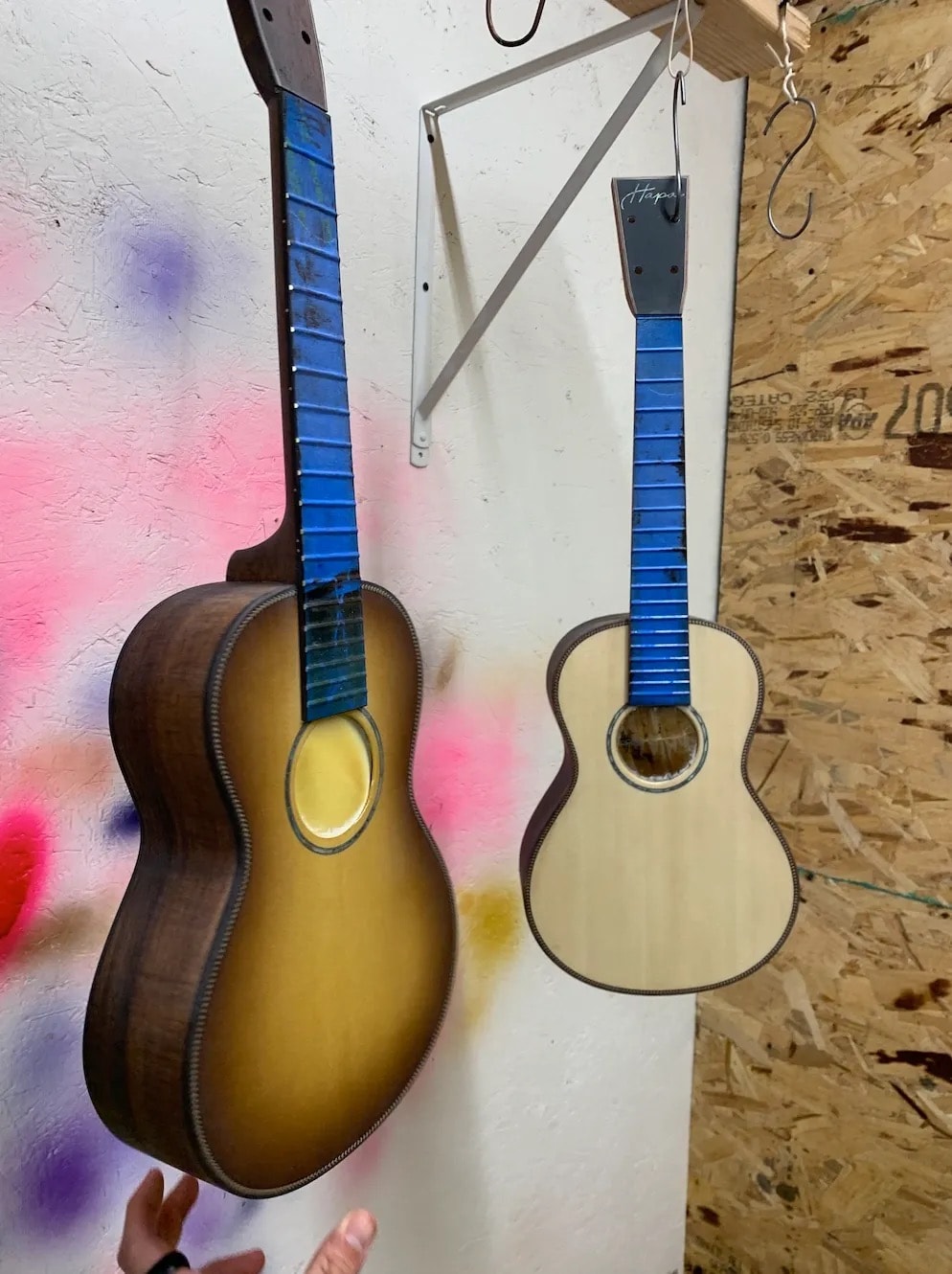 Acoustic ukuleles hanging on the workshop wall